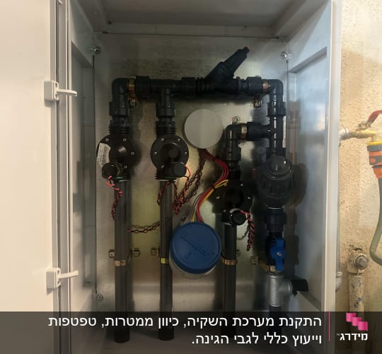 מערכת השקיה בתוך ארון פתוח עם צינורות ושסתומים